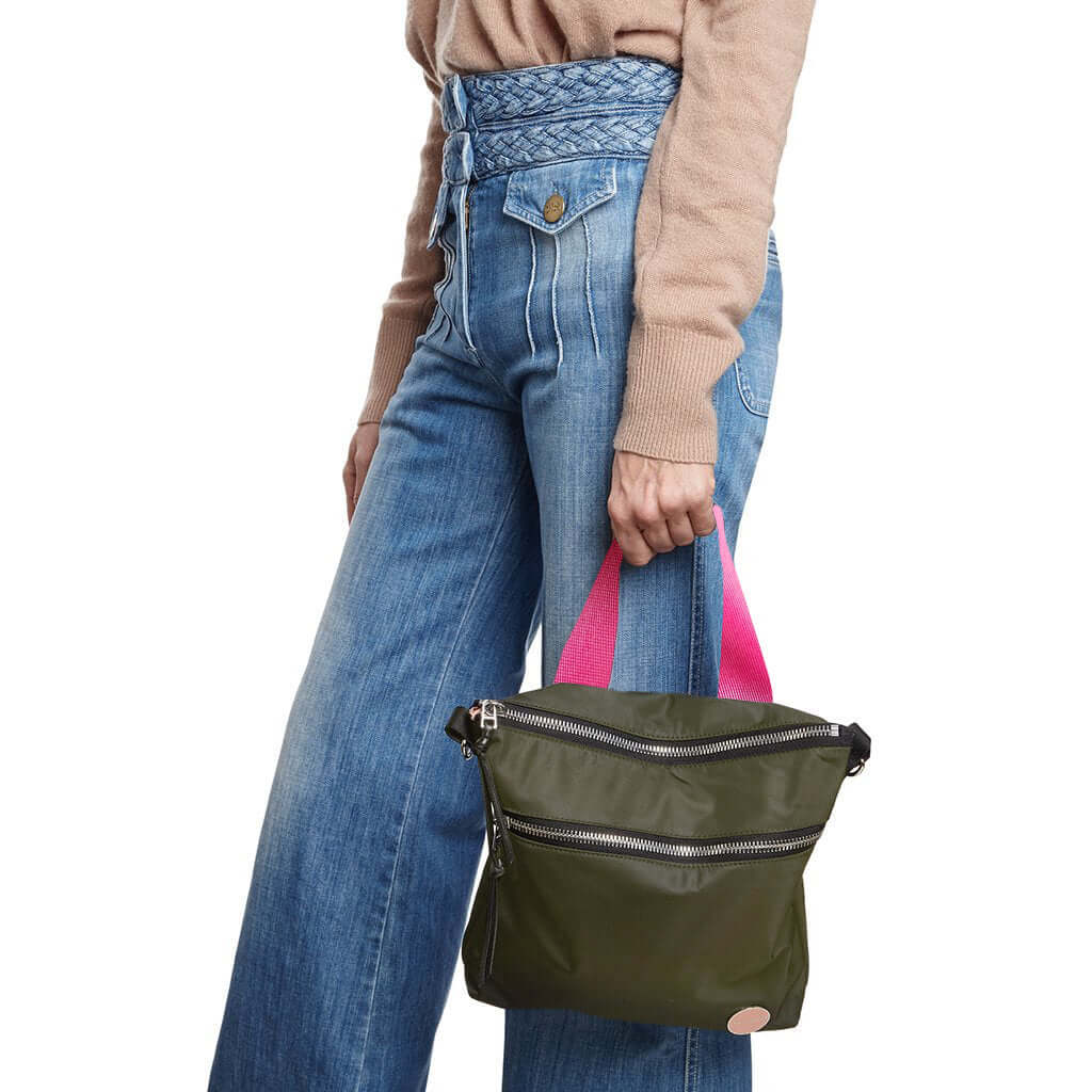 shortyLOVE amuse medium sized crossbody bag in army green; on model in tan v-neck long sleeve sweater and jeans against white background.