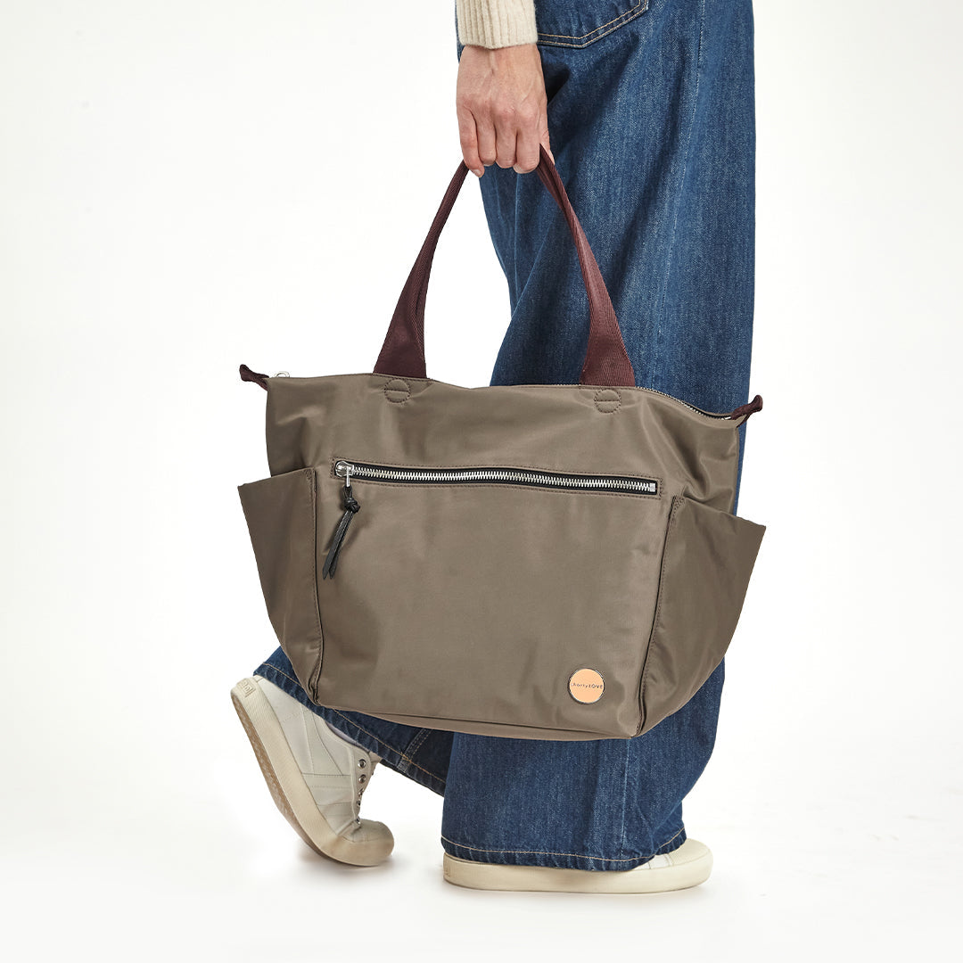 Person holding a mocha tillie tote bag with a white background