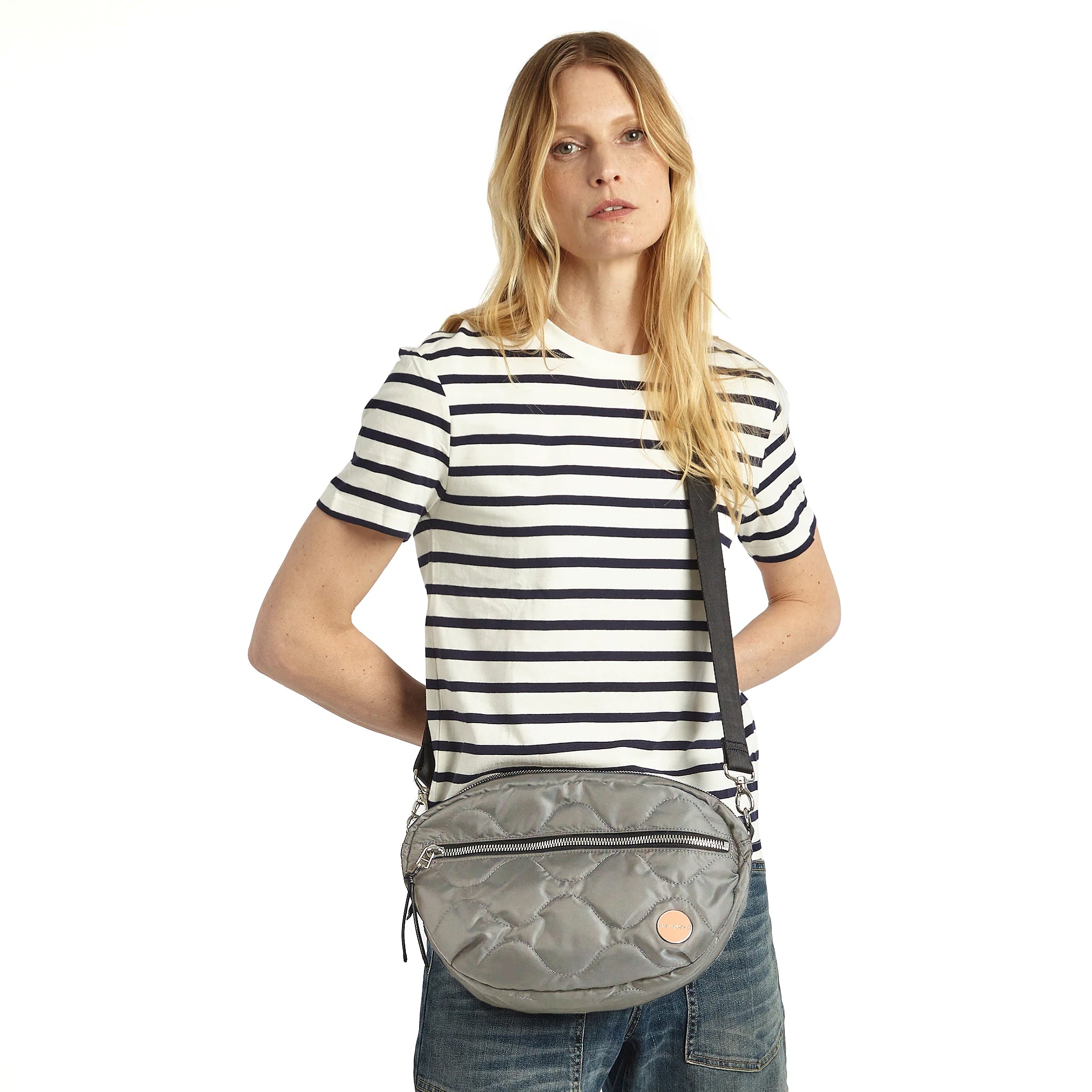 shortyLOVE cruiser medium crossbody bag in milky grey; on model in striped t-shirt and jeans against white background.