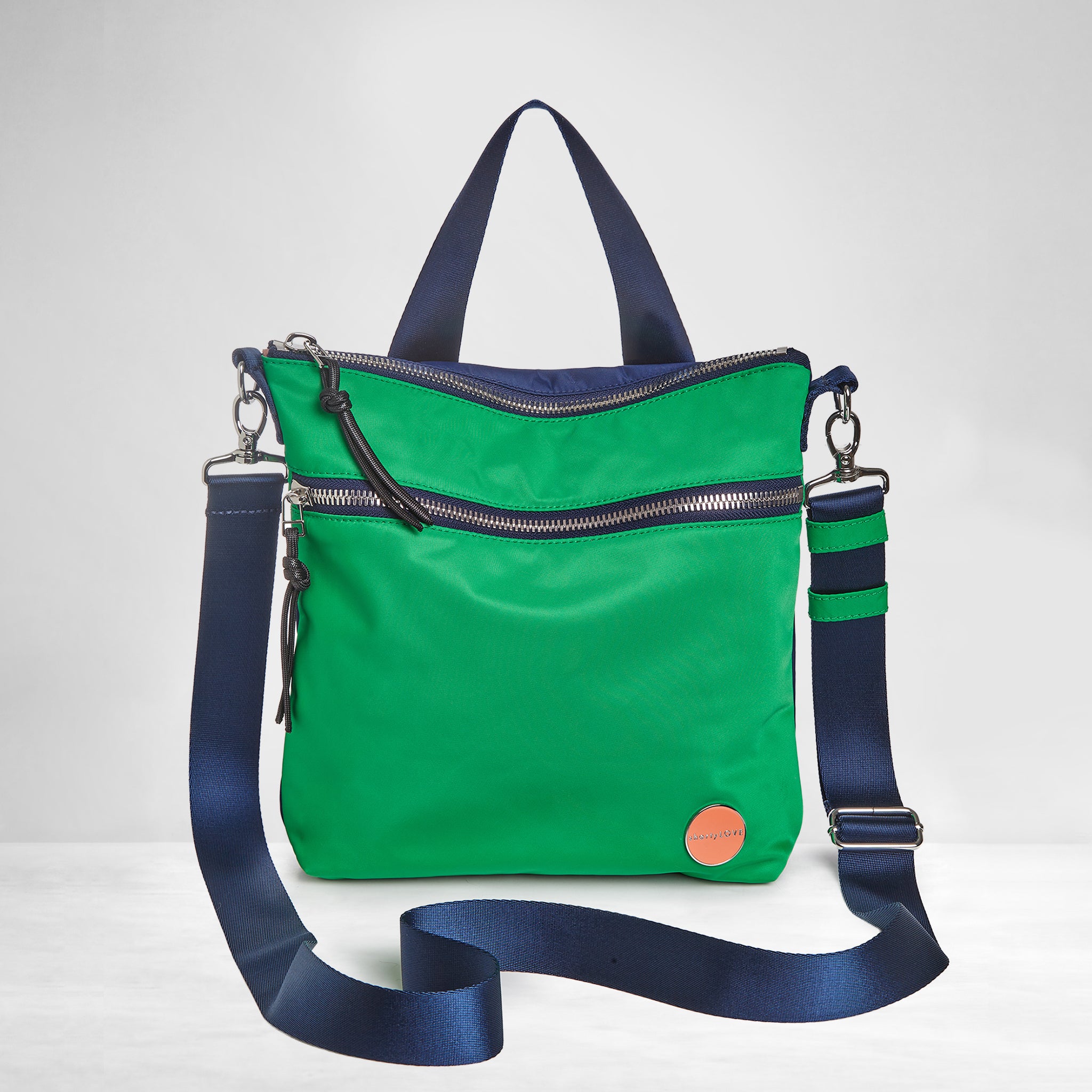 shortyLOVE amuse medium sized crossbody bag in grass green/navy; front view against grey background.