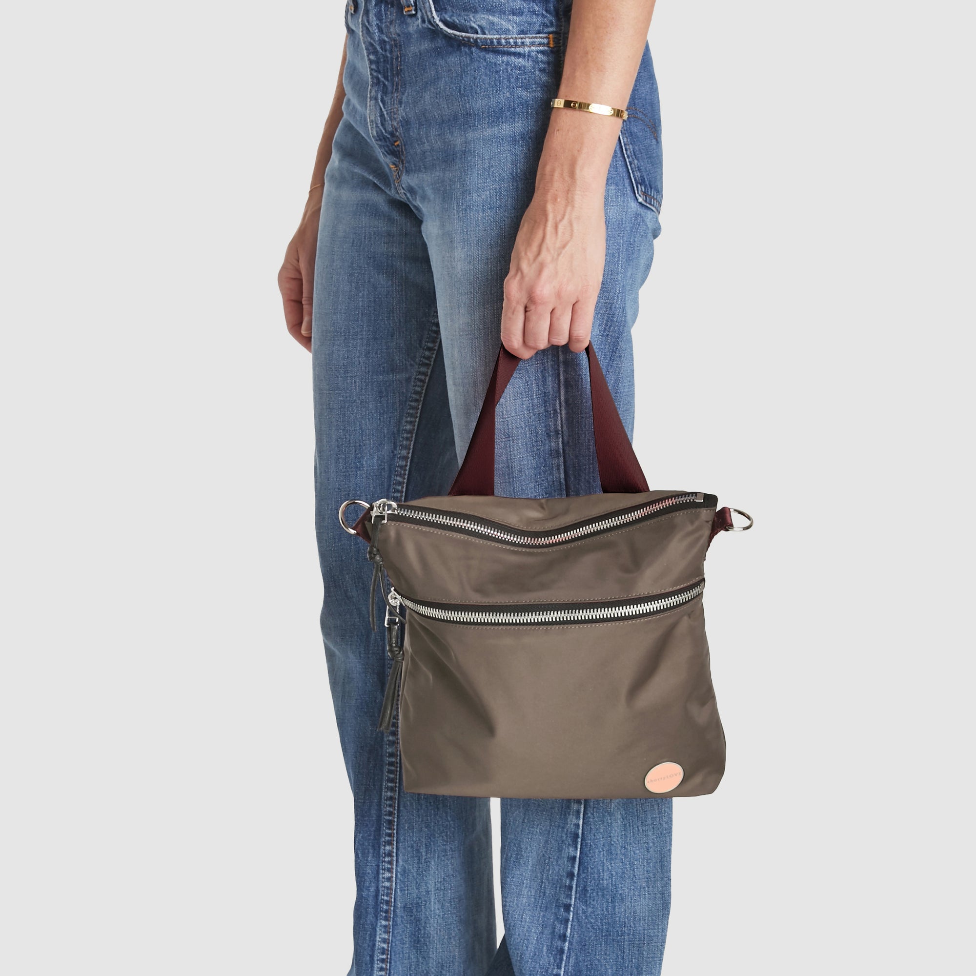 shortyLOVE amuse medium sized crossbody bag in mocha; hand held by model.