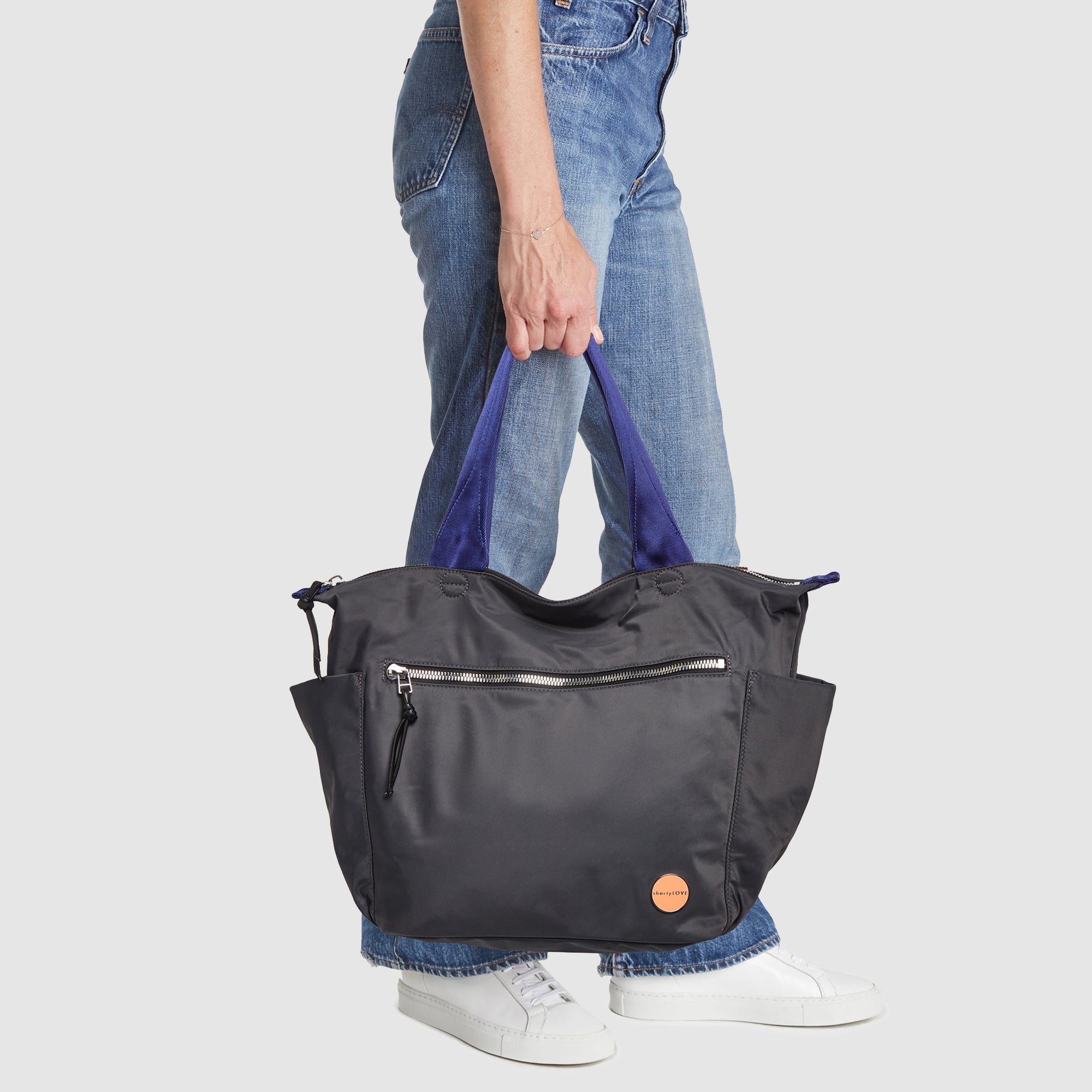 shortyLOVE tillie tote bag in charcoal; hand held by model in jeans against white background.