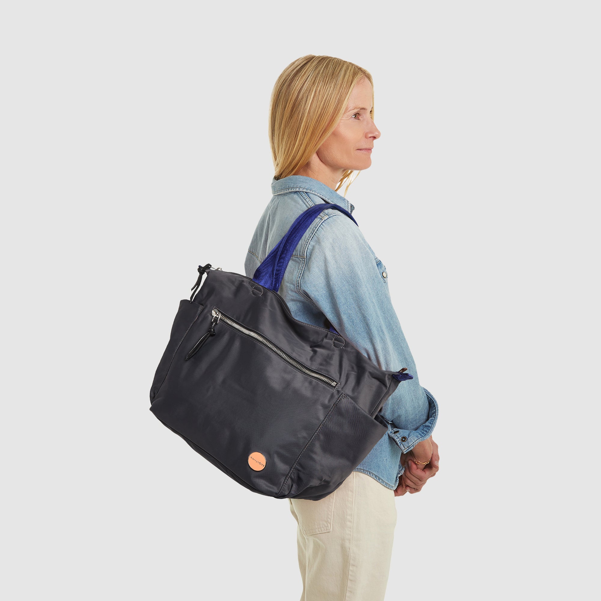 shortyLOVE tillie tote bag in charcoal; on shoulder of model in jeans against white background.