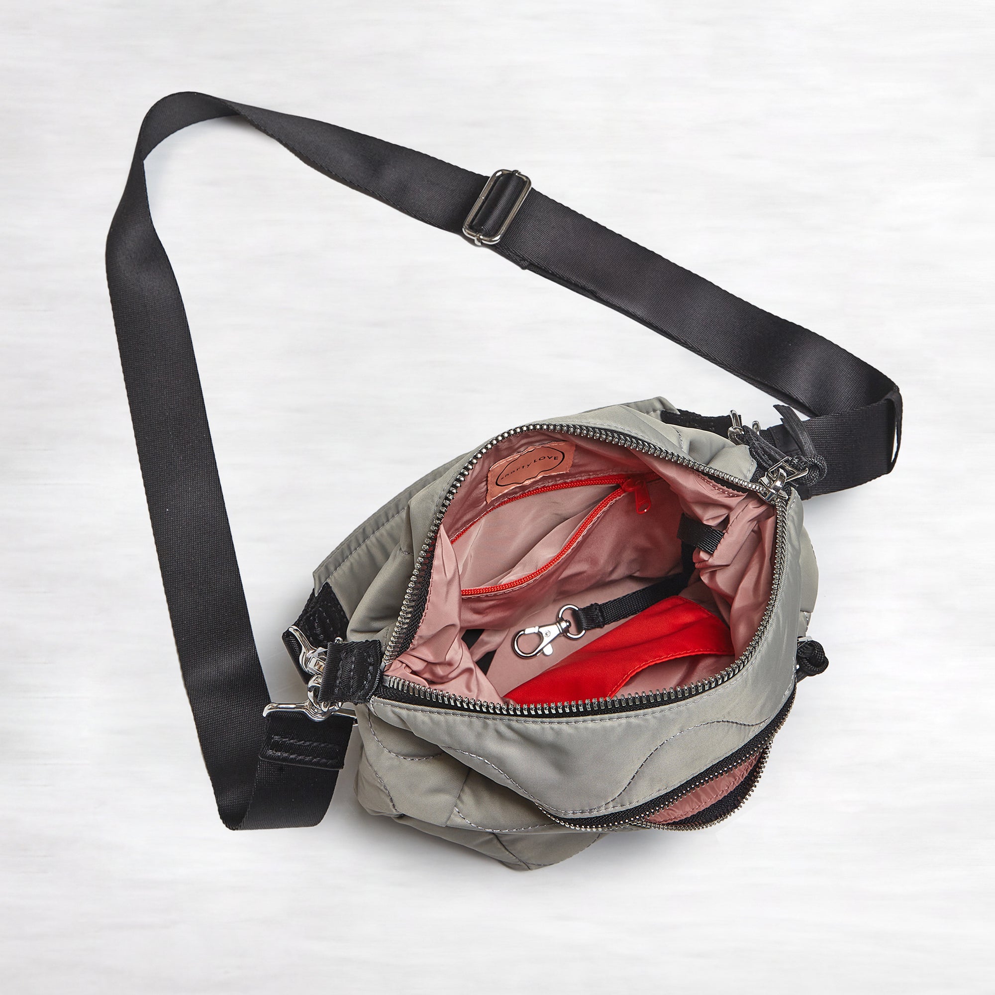 shortyLOVE marcel crossbody bucket bag in milky grey; top-down view showing interior blush lining against white background.