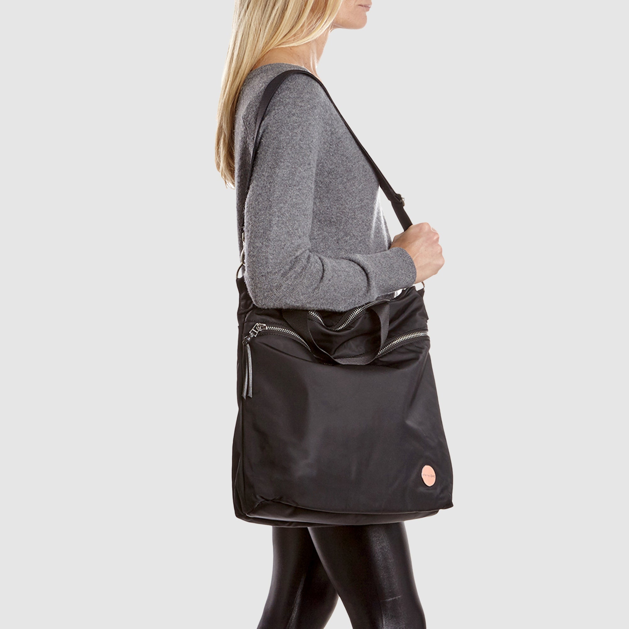 Person wearing a black wonder crossbody bag against a white background.