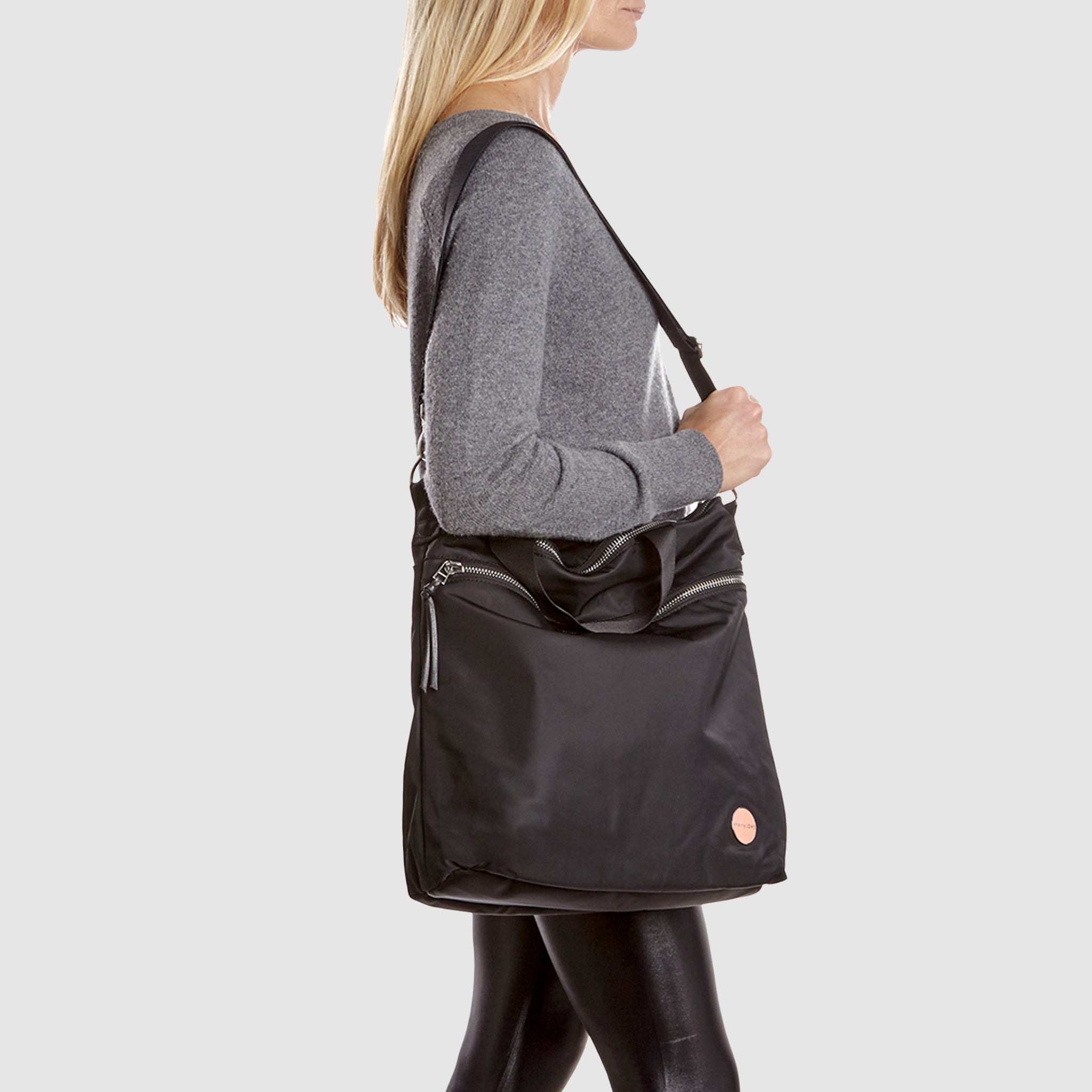 Person wearing a black wonder crossbody bag against a white background.