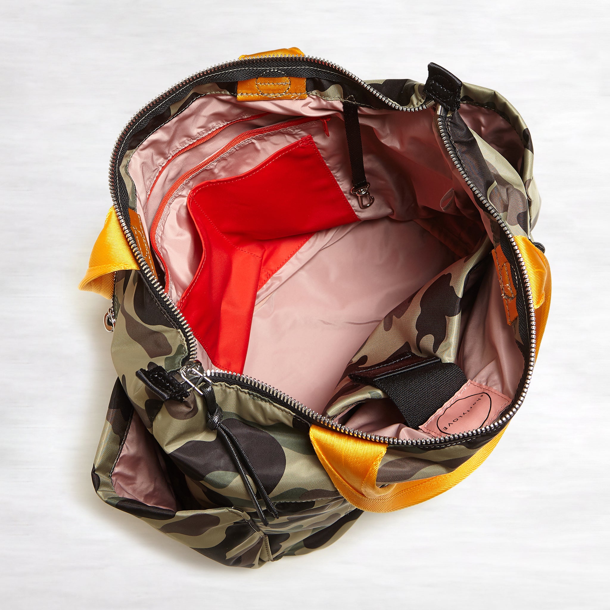 shortyLOVE tillie tote bag in green camo; top-down view showing interior pink lining against white background.