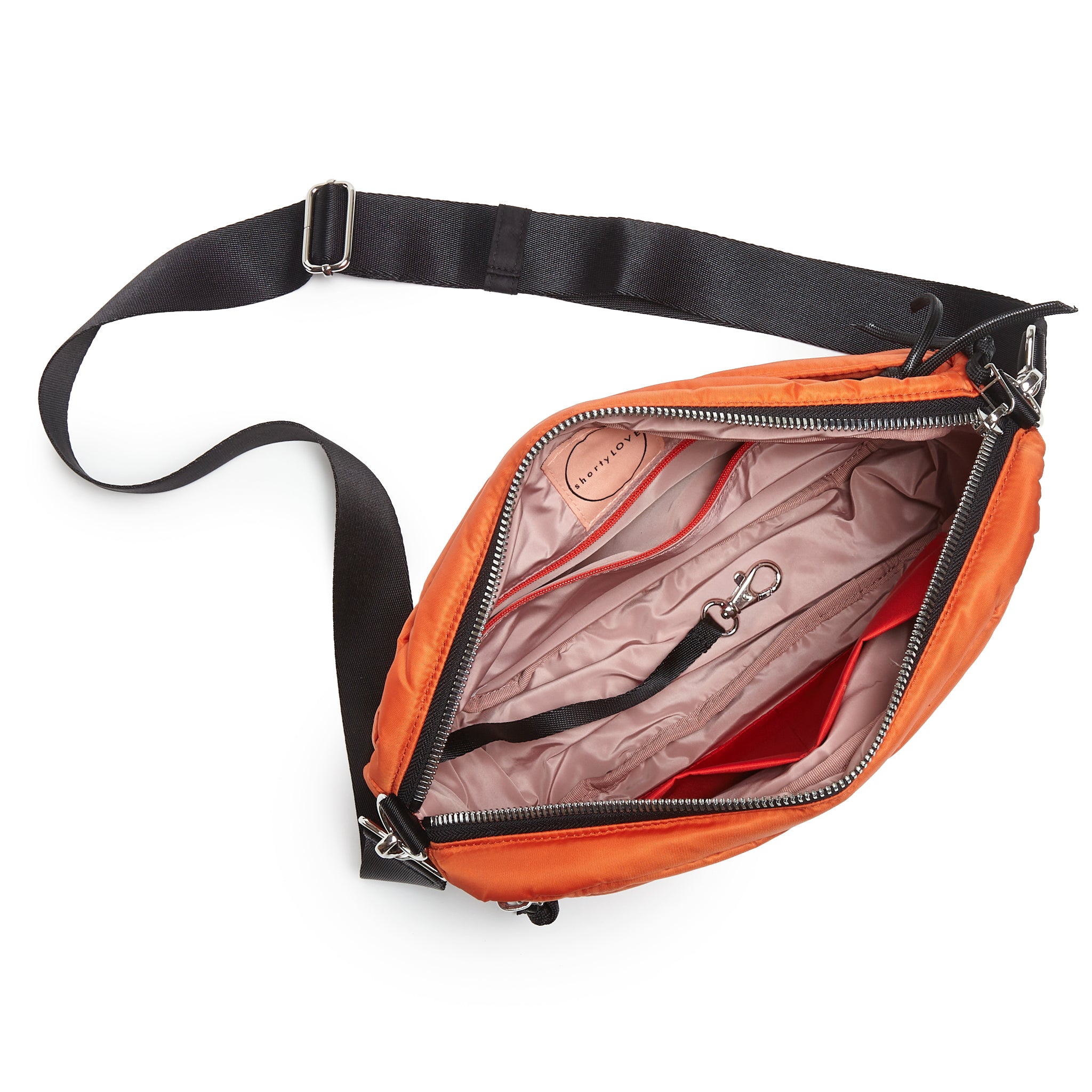 shortyLOVE cruiser medium crossbody bag in orange; top-down view showing interior blush lining against white background.