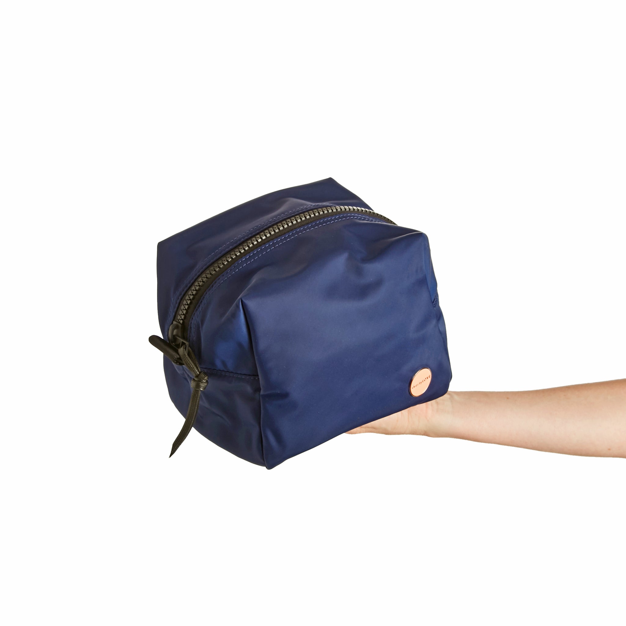 shortyLOVE stevie cosmetic bag in navy; hand held by model.
