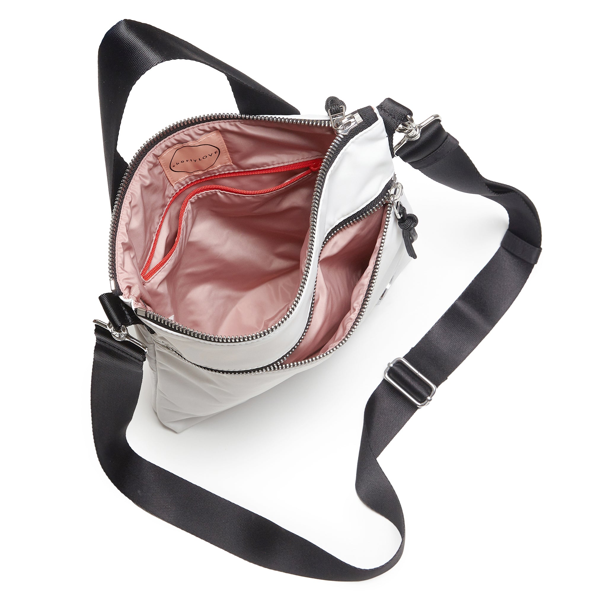 shortyLOVE amuse medium sized crossbody bag in white; top-down view showing interior blush/red lining against white background.