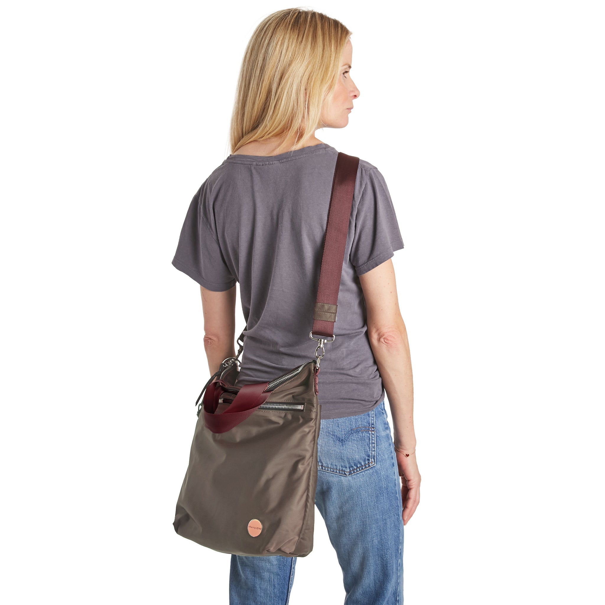 shortyLOVE wonder large crossbody/messenger bag in mocha; on model in grey t-shirt and jeans against white background.