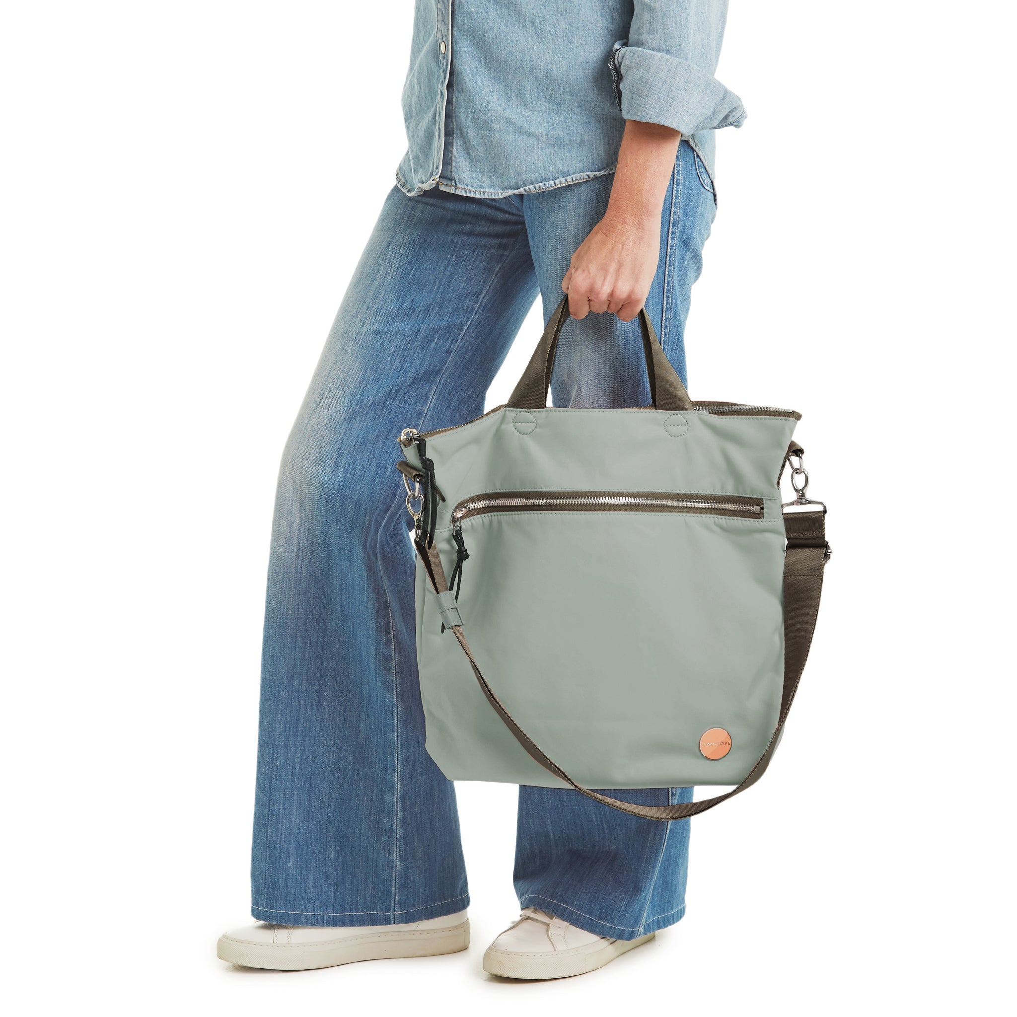 shortyLOVE wonder large crossbody/messenger bag in slate/teal; hand held by model in jeans against white background.