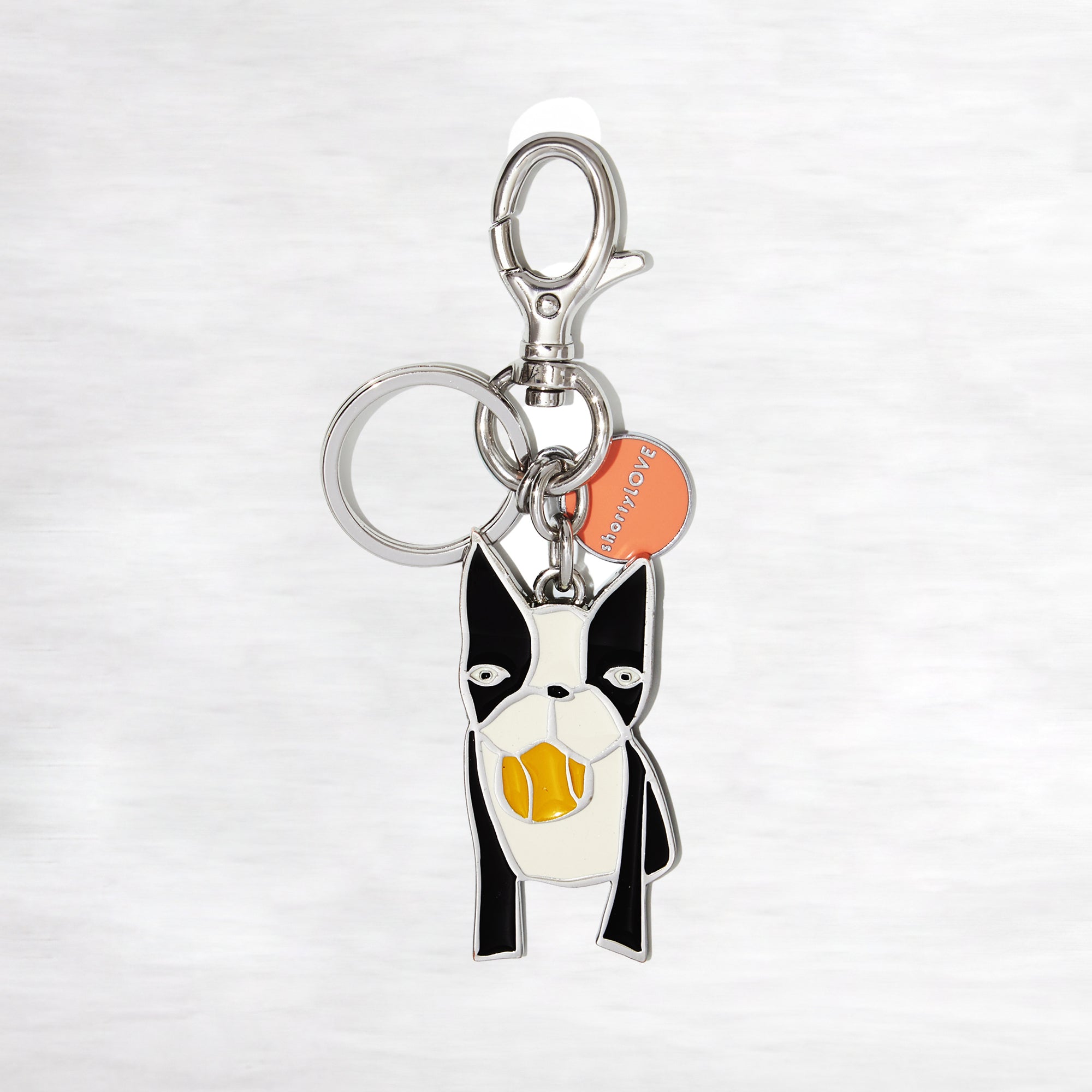 Keychain with a dog design and a visible brand logo on a light gray background