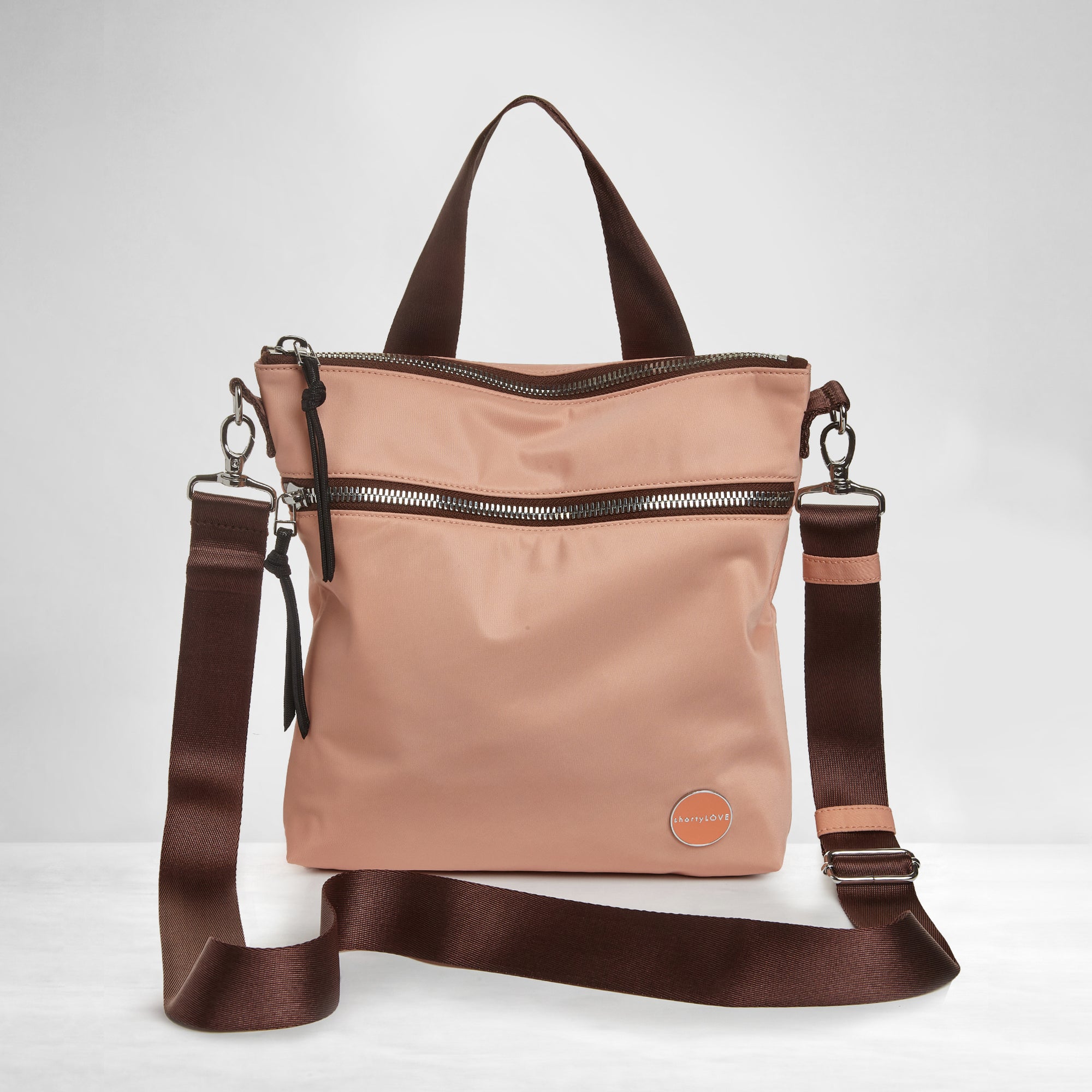 shortyLOVE amuse medium sized crossbody bag in dusty peach; front view against grey background.