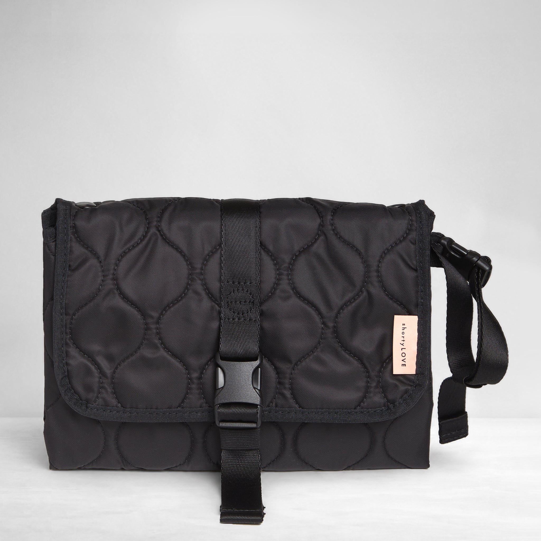 Black quilted diaper changing mat folded and closed - front view on a white background