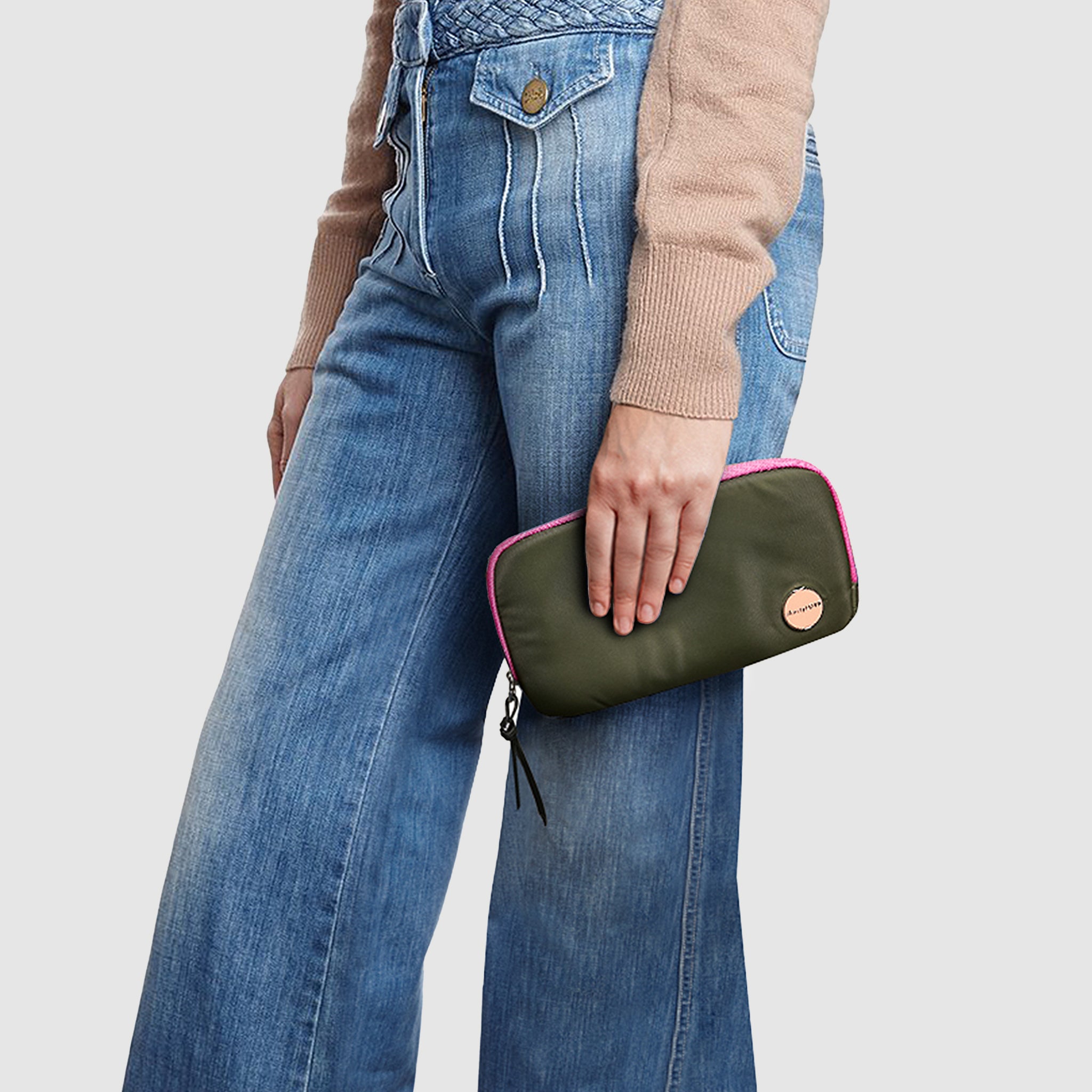shortyLOVE jetty clutch/wallet in army green; hand held by model in black sweatshirt and jeans against white background.