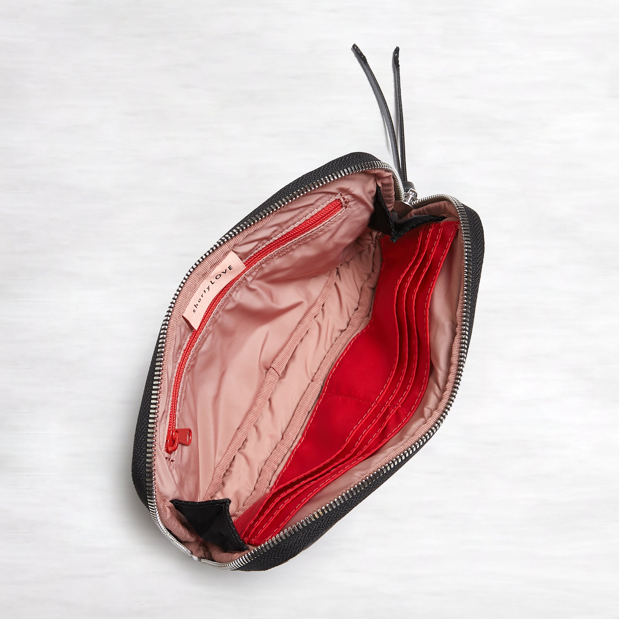 shortyLOVE jetty clutch/wallet in black; top-down view showing interior pink lining against white background.