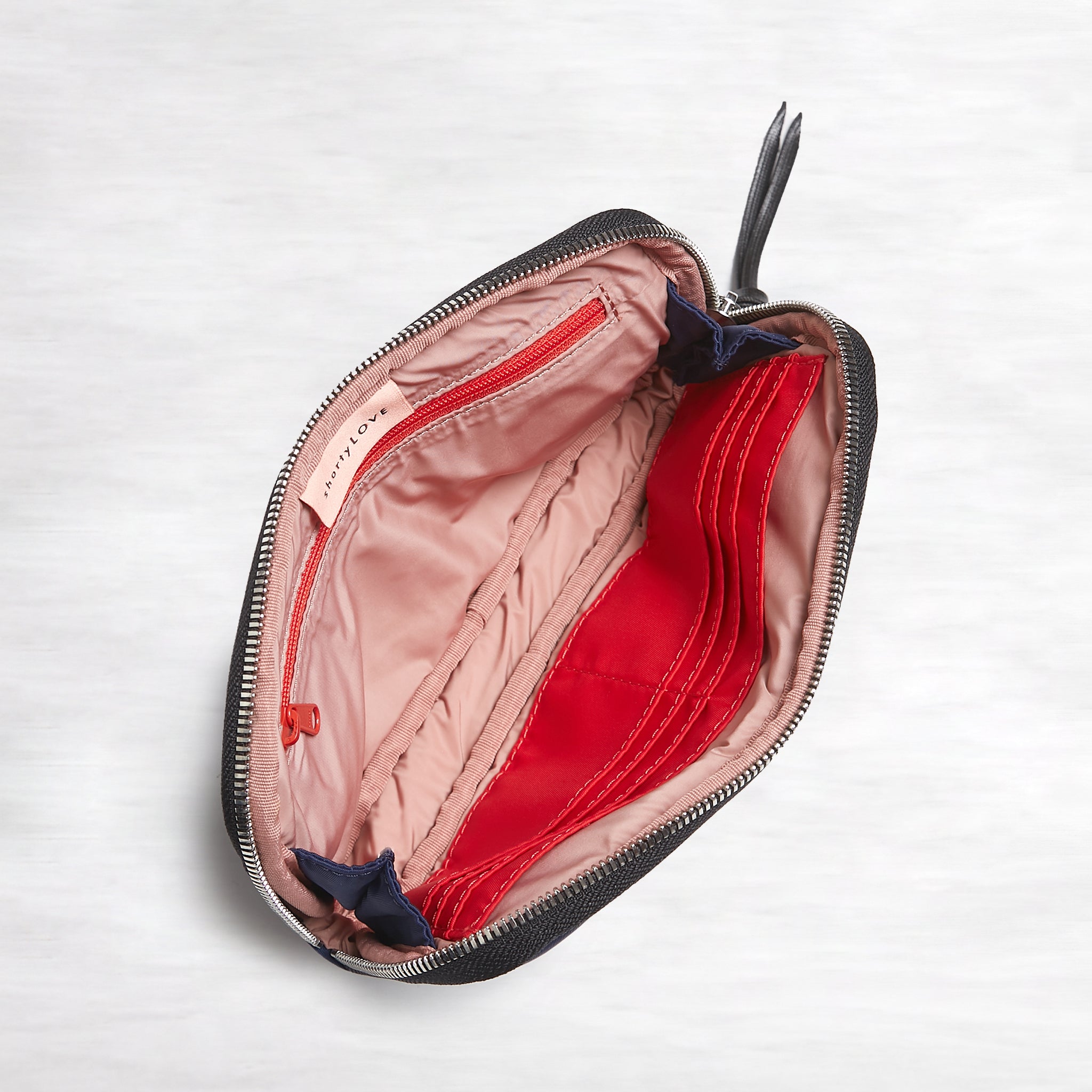 shortyLOVE jetty clutch/wallet in navy; top-down view showing interior pink lining against white background.
