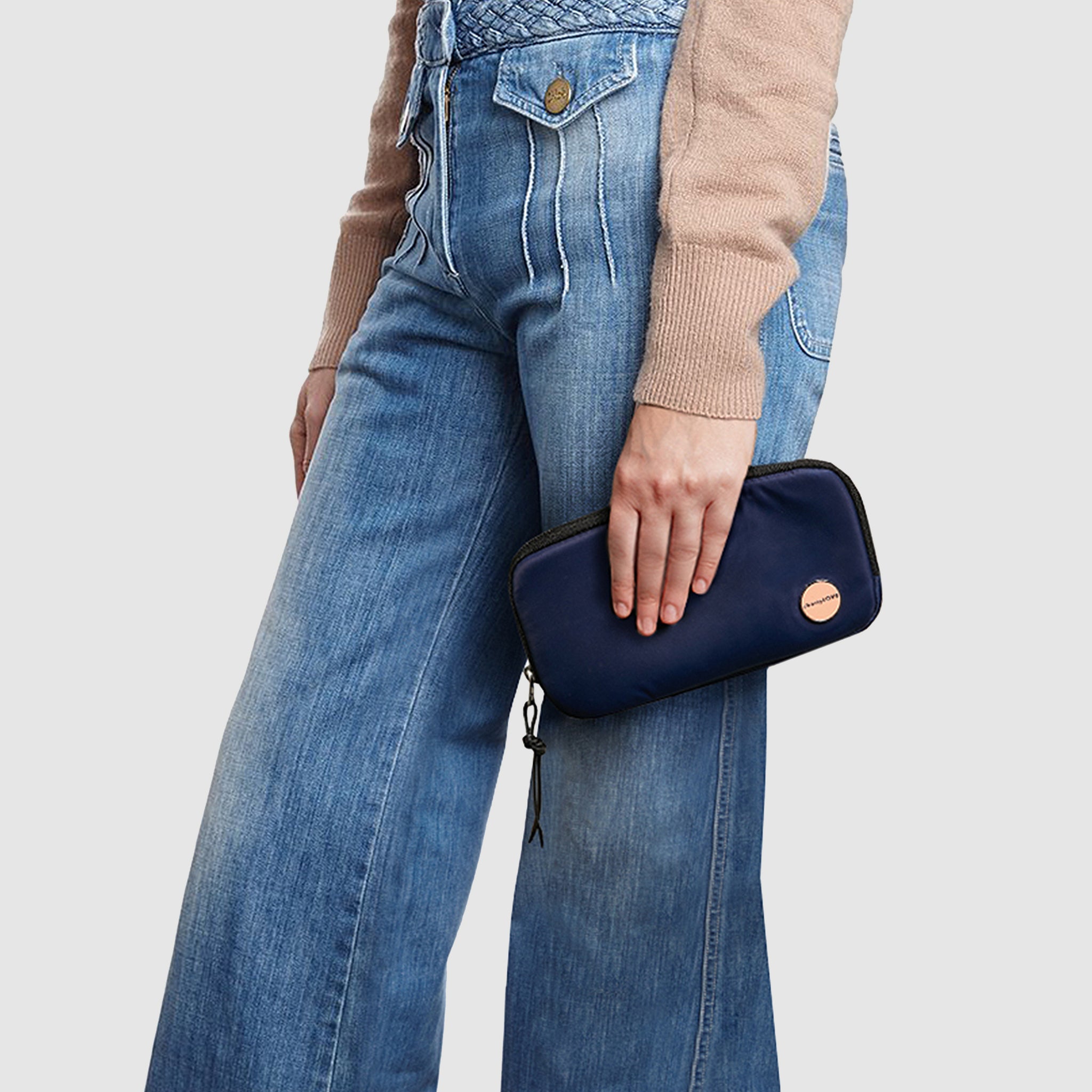shortyLOVE jetty clutch/wallet in navy; hand held by model in black sweatshirt and jeans against white background.
