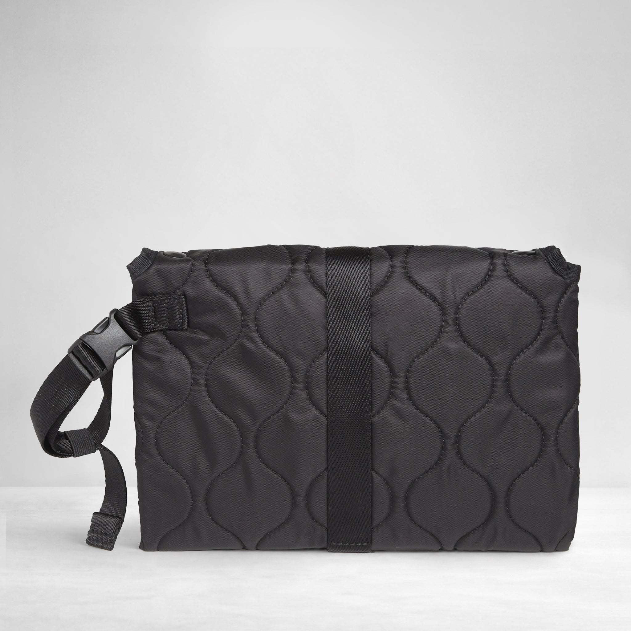 Black quilted diaper changing mat folded and closed - back view on a white background