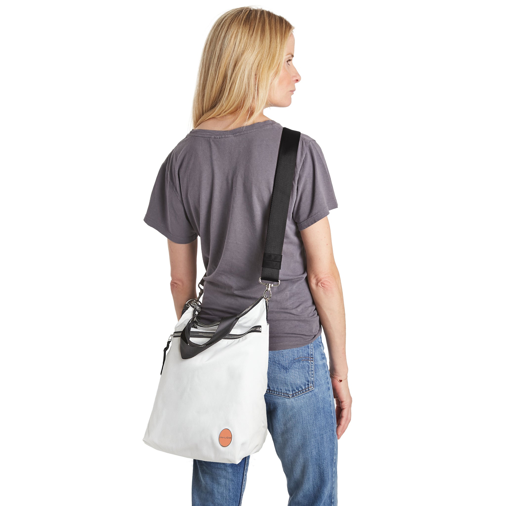 shortyLOVE wonder large crossbody/messenger bag in white; on model in grey t-shirt and jeans against white background.