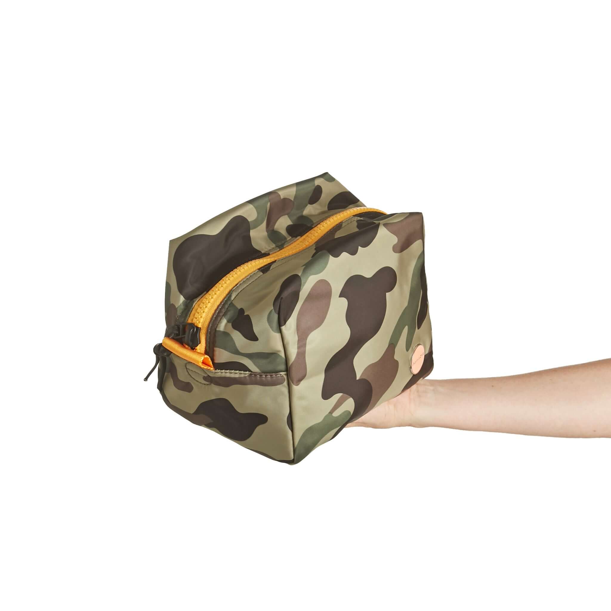 shortyLOVE stevie cosmetic bag in green camo; hand held by model.