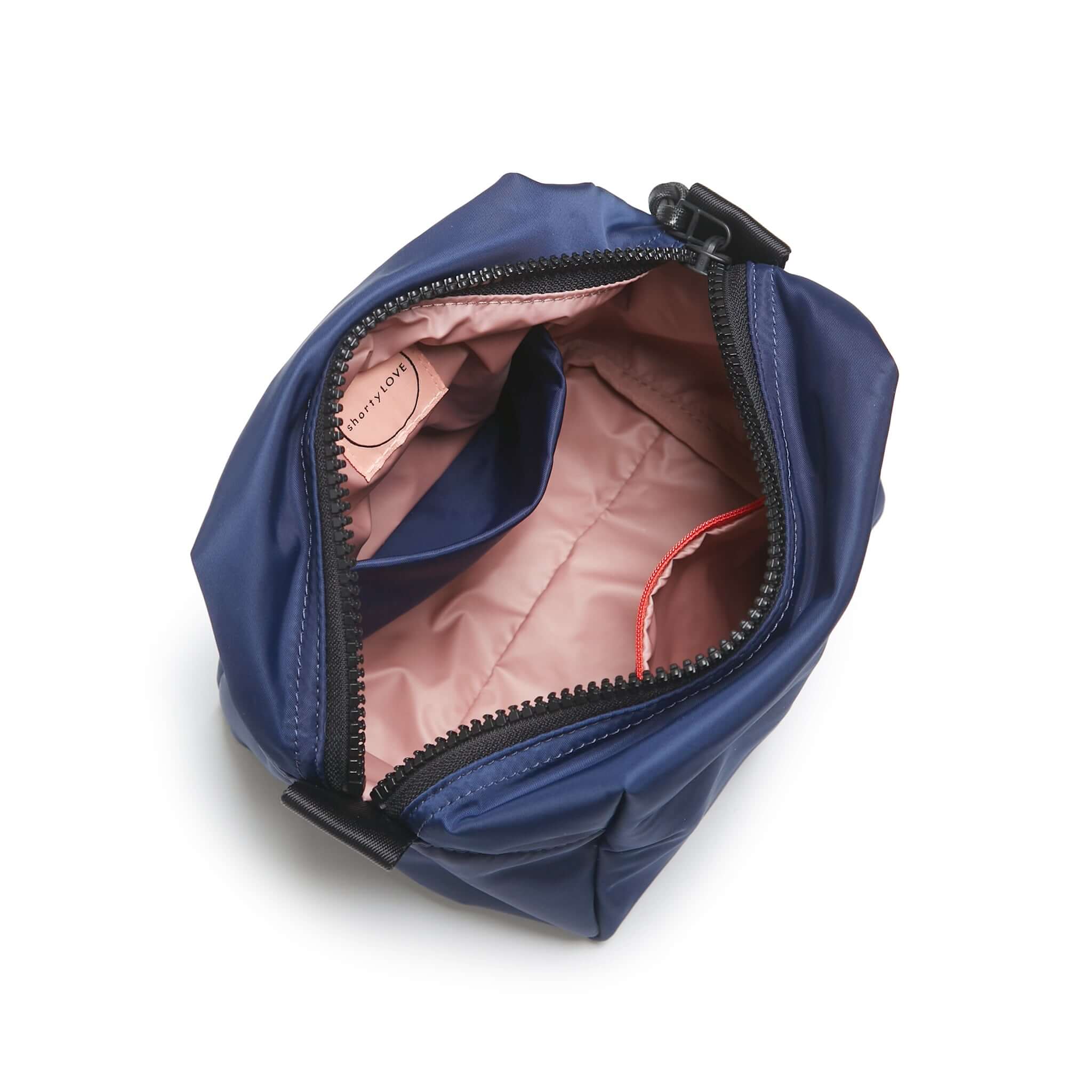 shortyLOVE stevie cosmetic bag in navy; top-down view showing interior pink lining against white background.