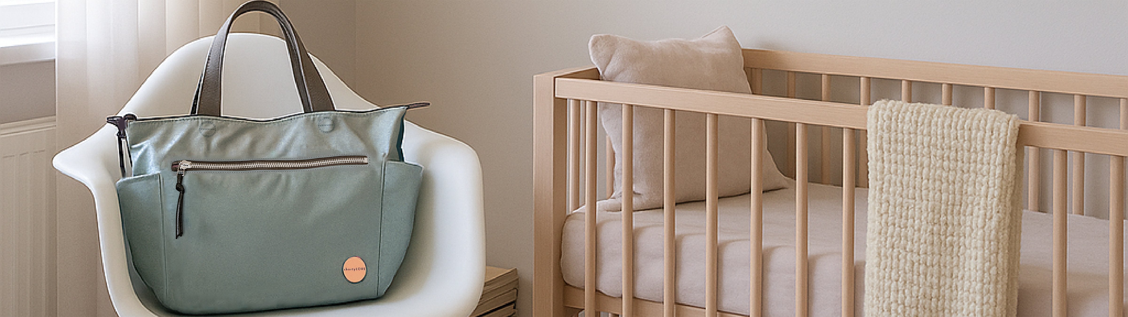 image of tillie tote bag in slate/teal on chair in baby's nursery