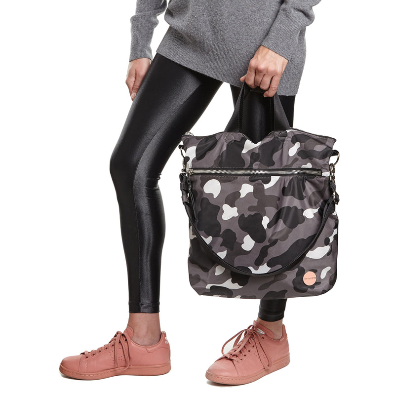 shortyLOVE wonder large crossbody/messenger bag in grey camo; hand held by model in black leggings against white background.