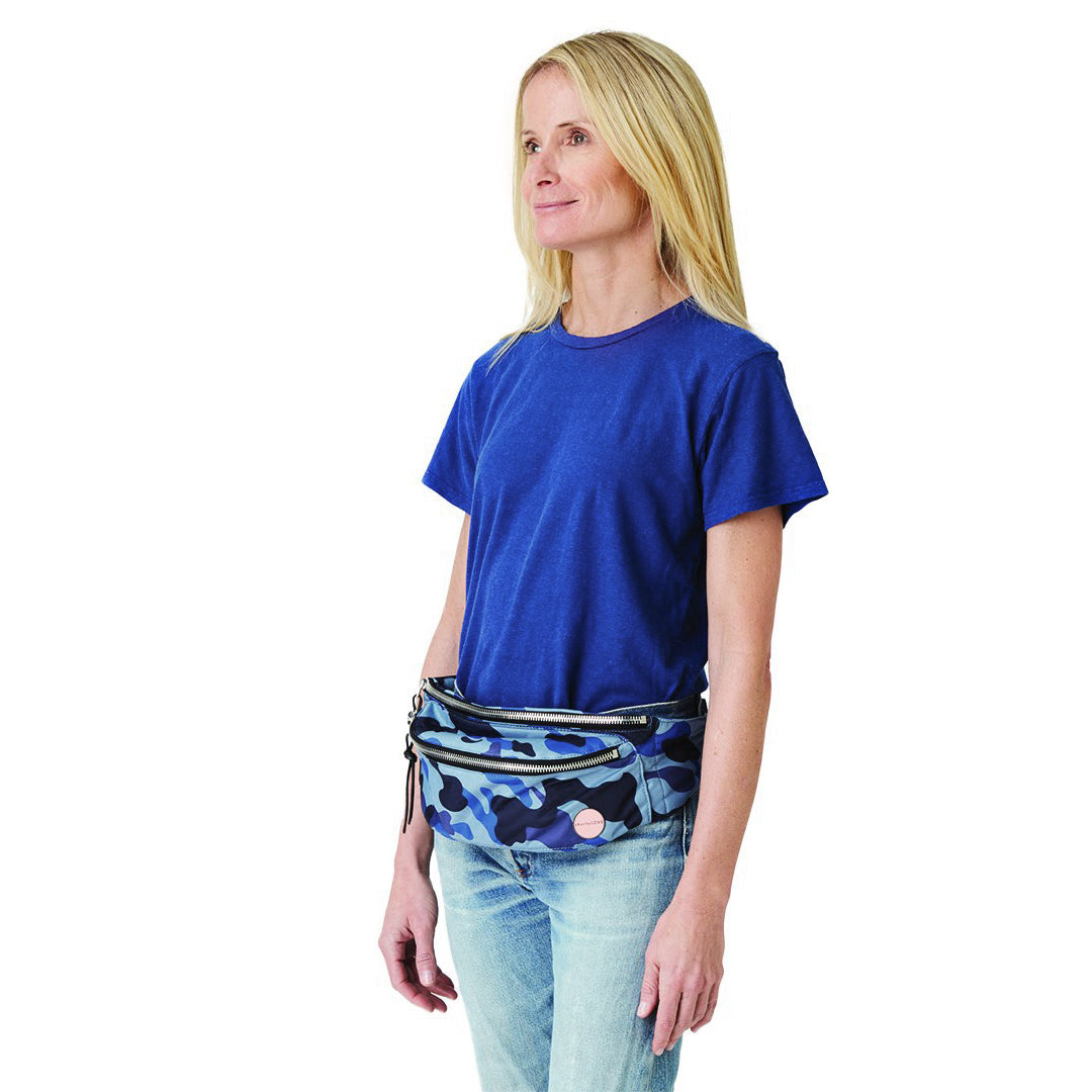 shortyLOVE arcade belt bag in blue camo; on model worn crossbody in gblue t-shirt and jeans against white background.