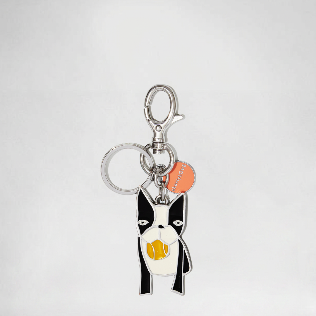 Keychain with a dog design and a visible brand logo on a light gray background