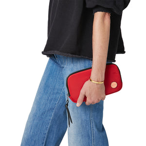 shortyLOVE jetty clutch/wallet in red; hand held by model in jeans against white background.