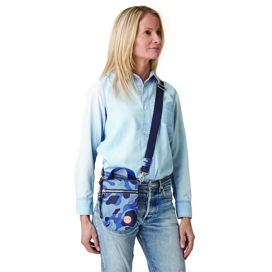 shortyLOVE shorthand small crossbody bag in blue camo; on model in blue top and jeans against white background.