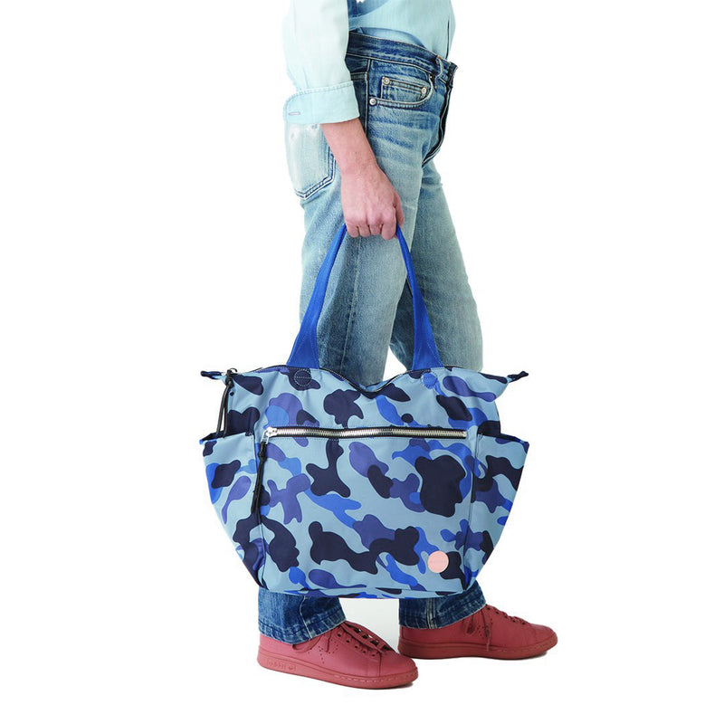 shortyLOVE wonder large crossbody/messenger bag in blue camo; hand held by model in jeans against white background.