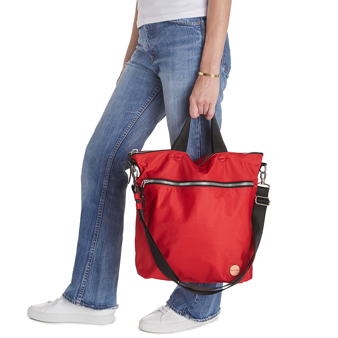 shortyLOVE wonder large crossbody/messenger bag in red; hand held by model in jeans against white background.