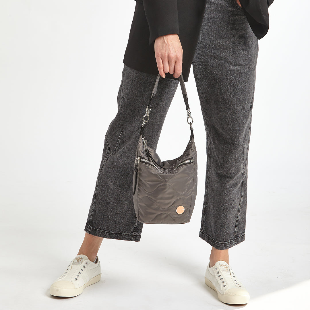 pewter grey marcel quilted crossbody  handheld against a white background