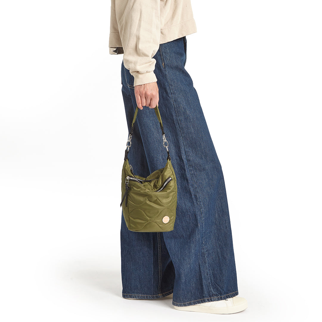 sage marcel quilted crossbody  handheld against a white background