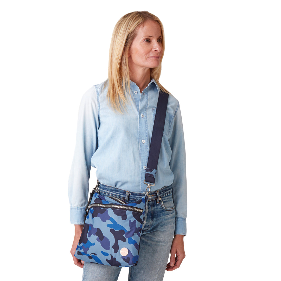 shortyLOVE arcade belt bag in blue camo; on model worn crossbody in blue top and jeans against white background.