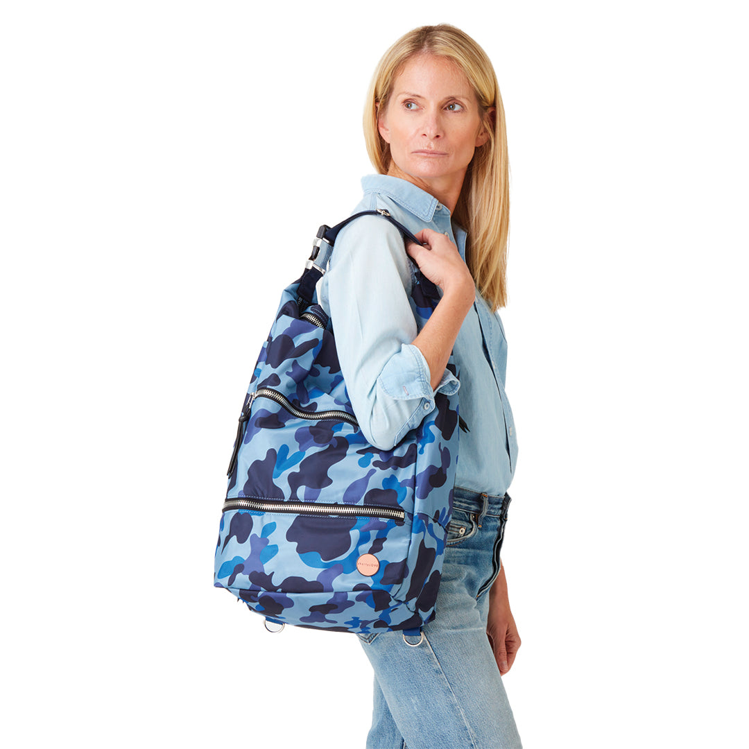 shortyLOVE boxer backpack in blue camo; on model over shoulder in blue top and jeans against white background.