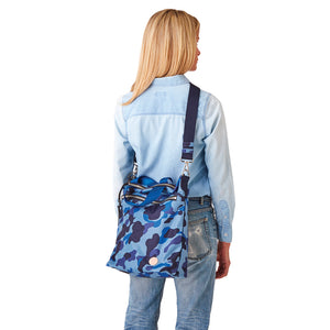 shortyLOVE wonder large crossbody/messenger bag in blue camo; on model in blue top and jeans against white background.
