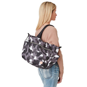 shortyLOVE tillie tote bag in grey camo; on model in peach top and jeans against white background.