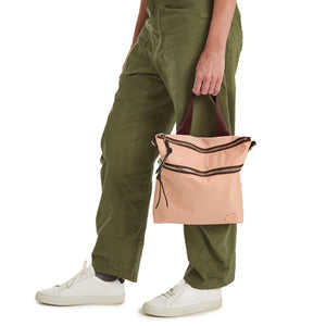 shortyLOVE amuse medium sized crossbody bag in dusty peach; hand held by model.