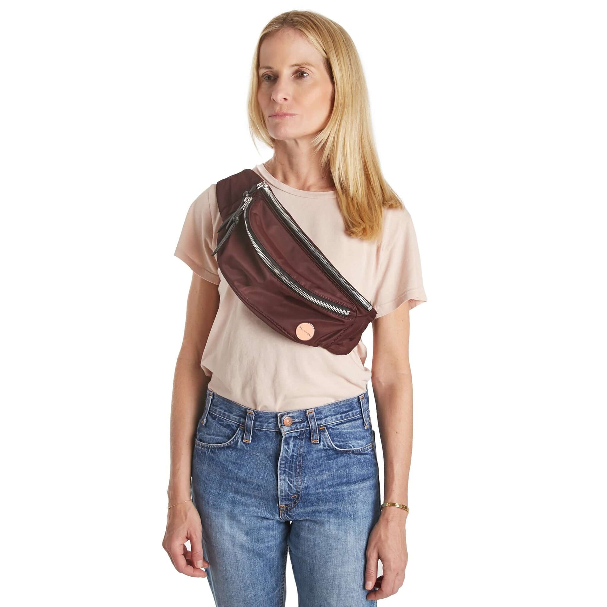 shortyLOVE arcade belt bag in burgundy; on model worn crossbody in peach t-shirt and jeans against white background.