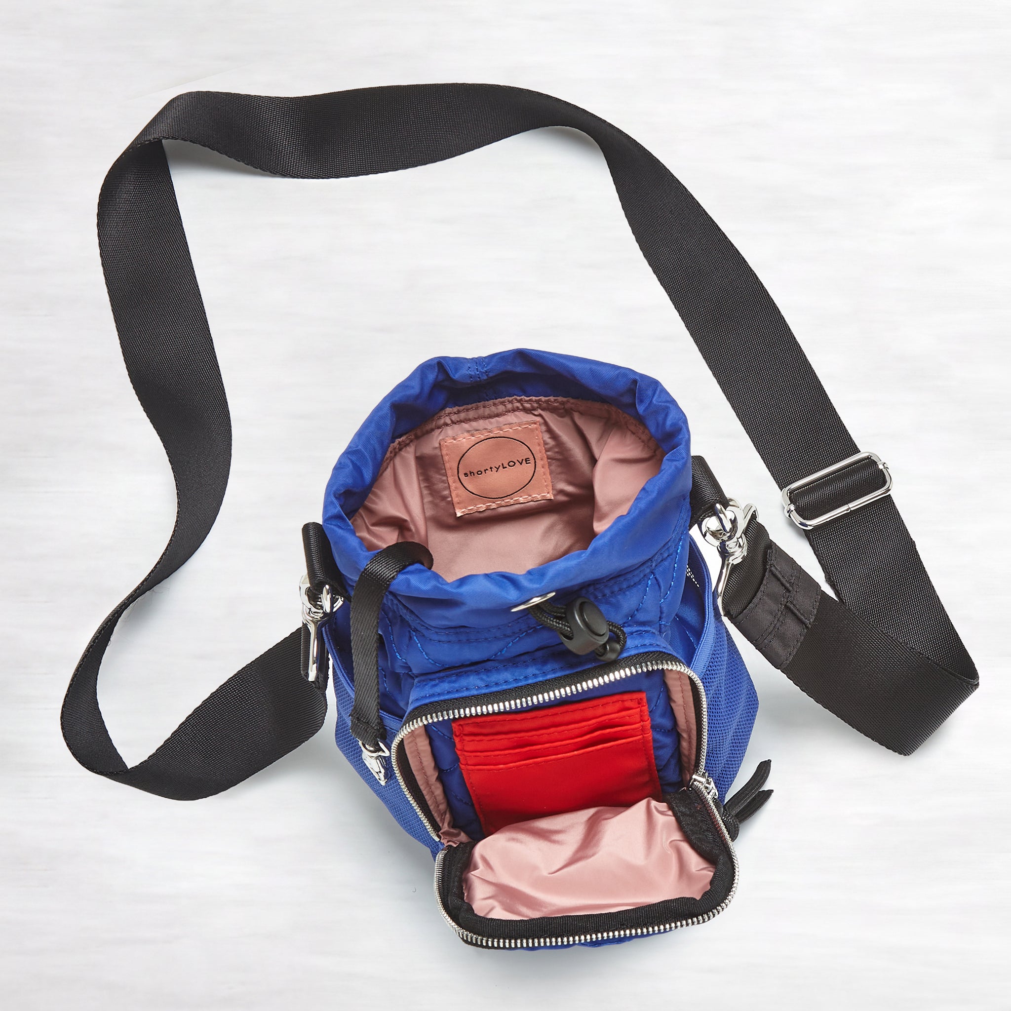 shortyLOVE bea sling bag in electric blue; top-down view showing interior blush lining against grey background.