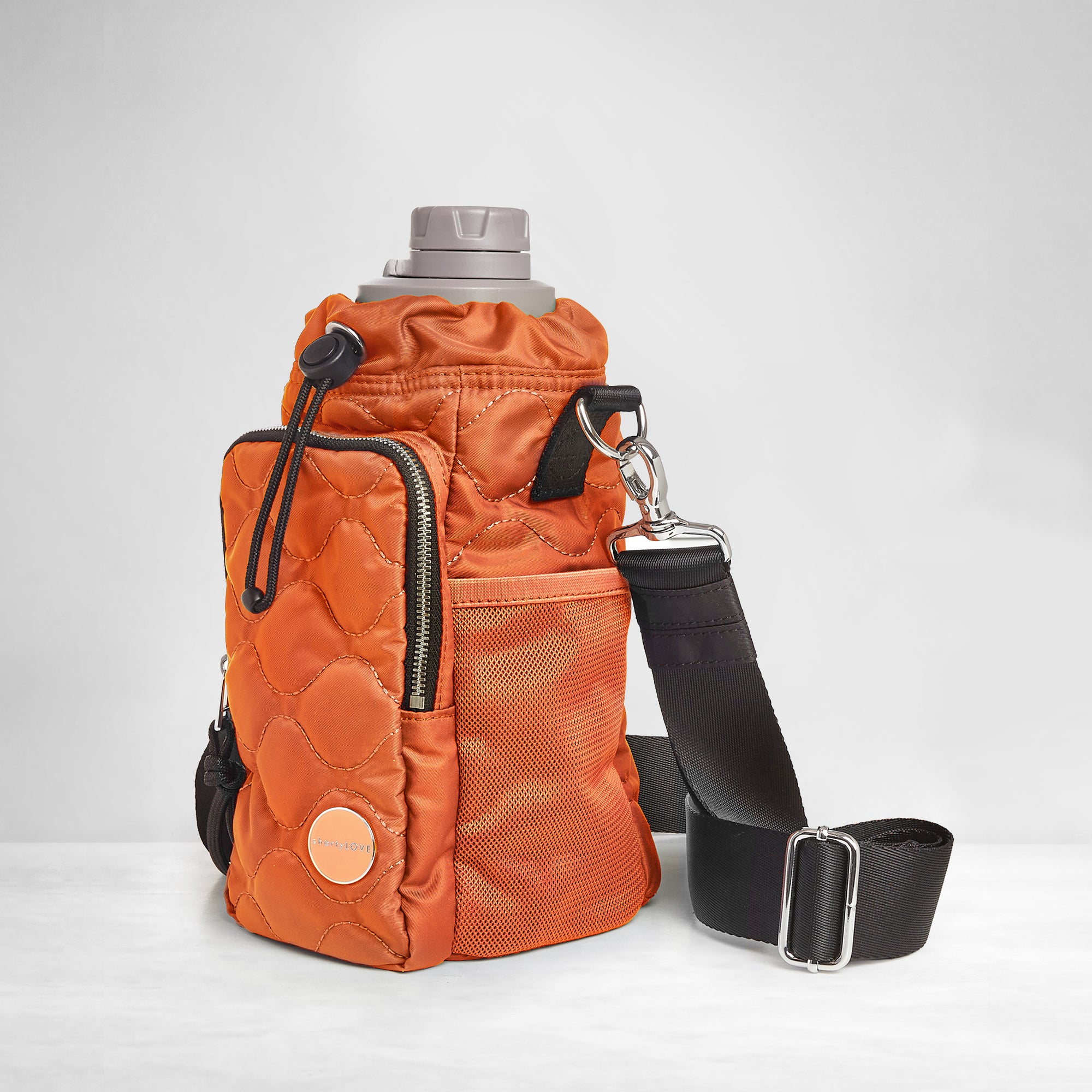 shortyLOVE bea sling bag in orange; side view against grey background.