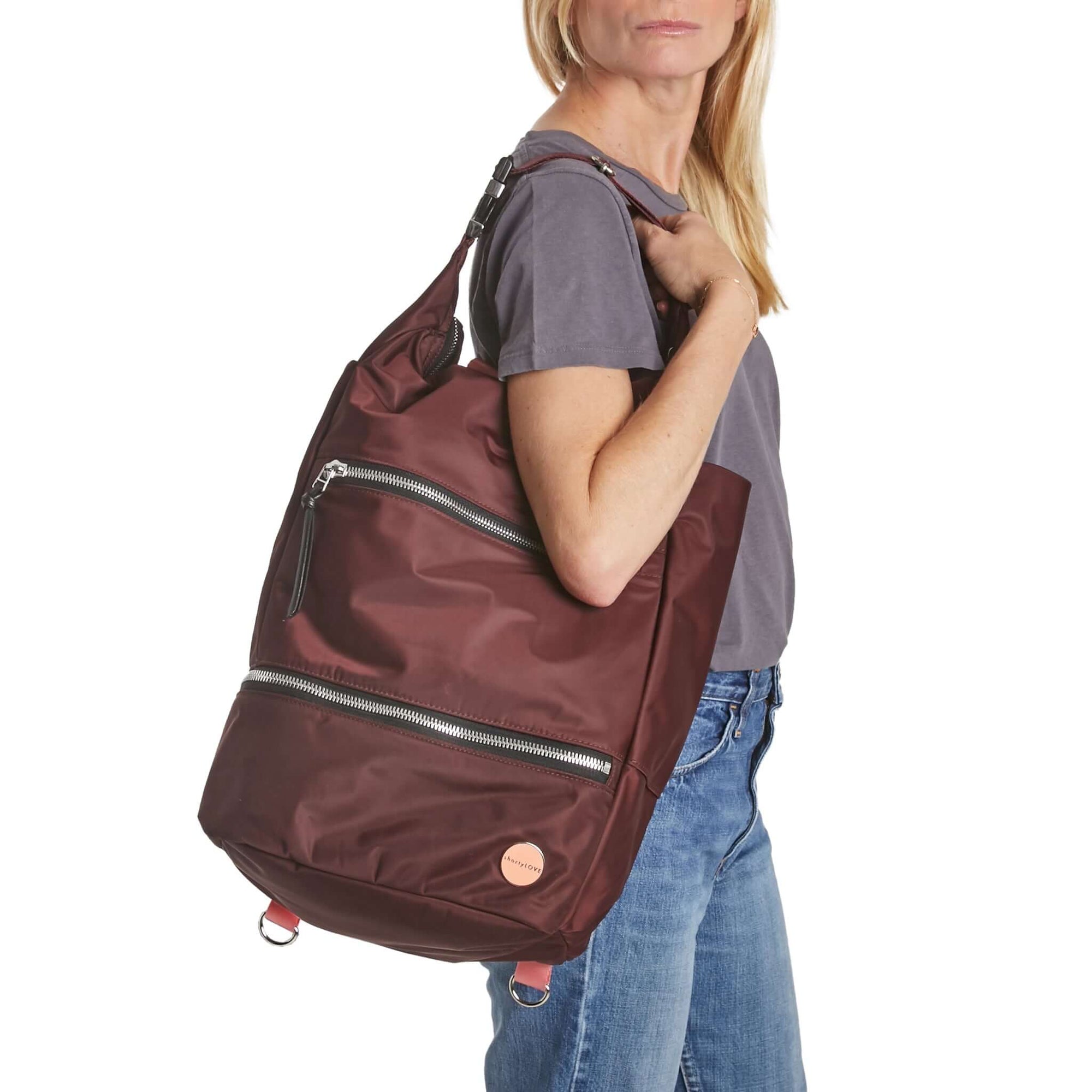 shortyLOVE boxer backpack in burgundy; on model over shoulder in grey t-shirt and jeans against white background.
