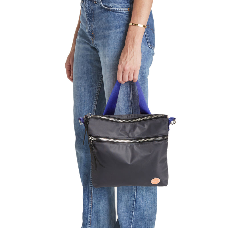 shortyLOVE amuse medium sized crossbody bag in charcoal; hand held by model.