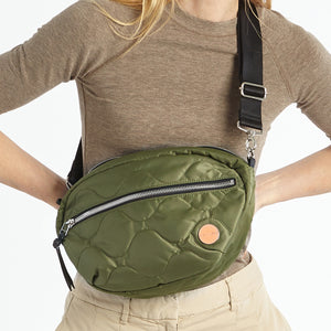 shortyLOVE cruiser medium crossbody bag in sage; on model in a tan top and pants against white background.