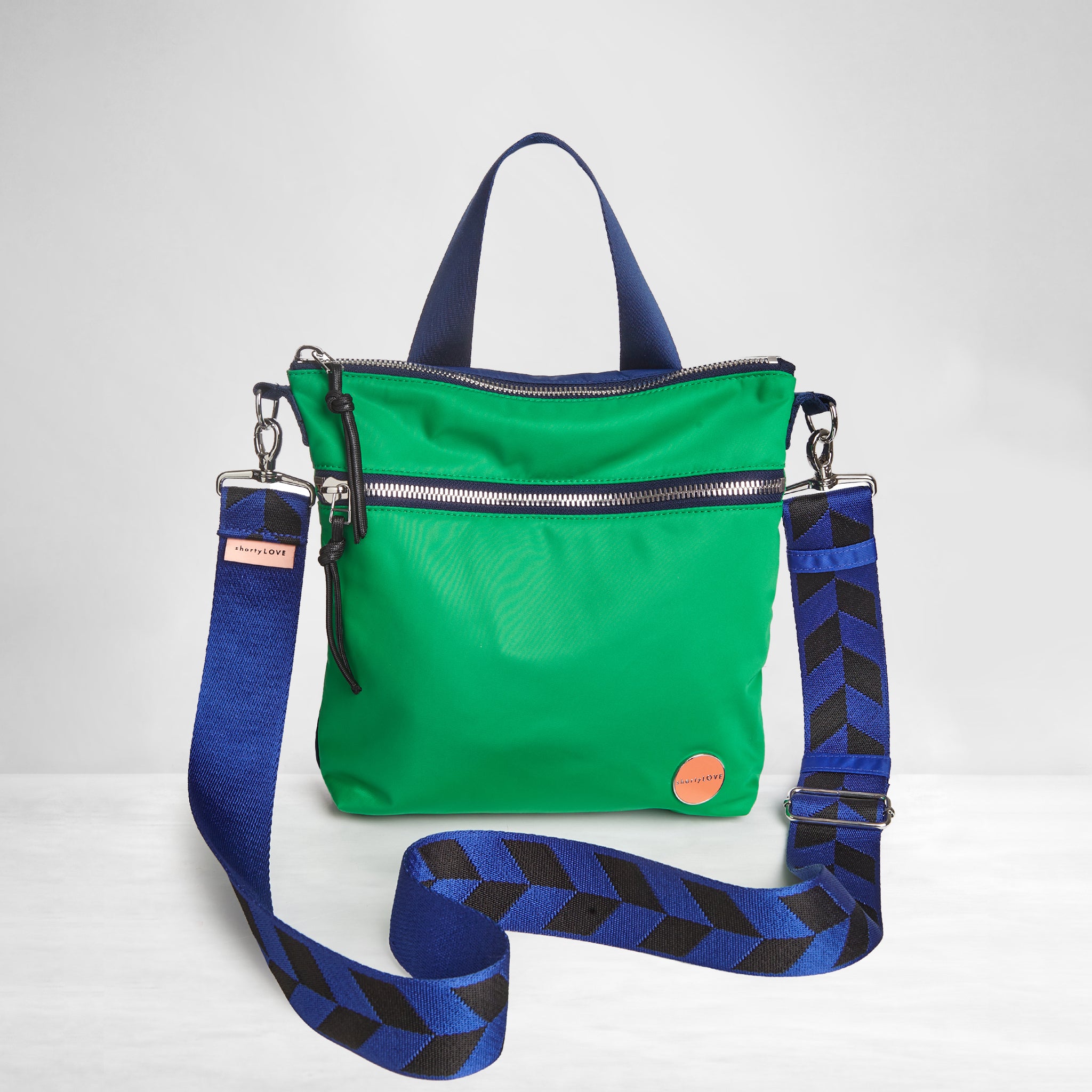 shortyLOVE amuse medium sized crossbody bag in grass green/navy with arrow electric blue/black boardwalk strap; front view against white background.