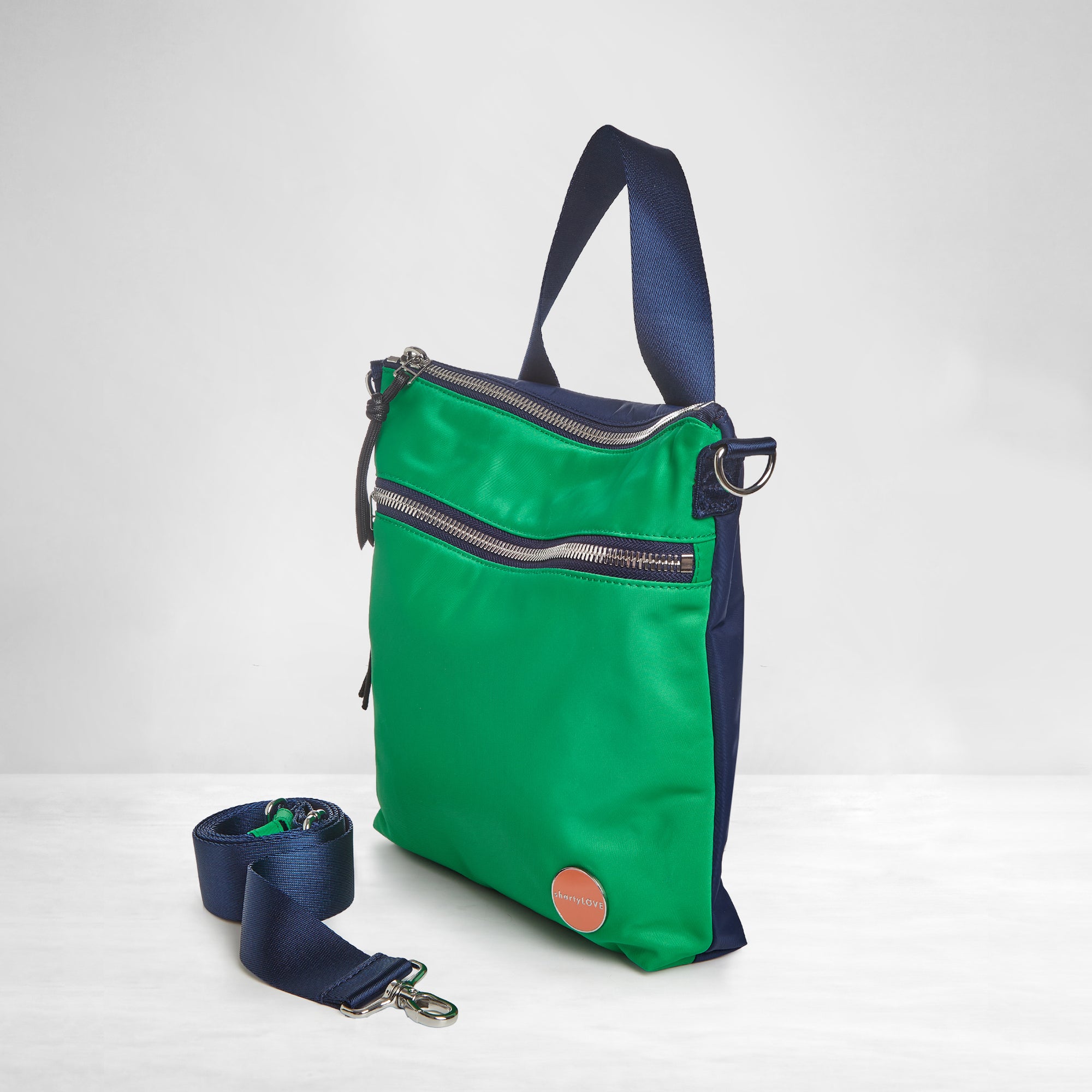 shortyLOVE amuse medium sized crossbody bag in grass green/navy; side angle view against white background.